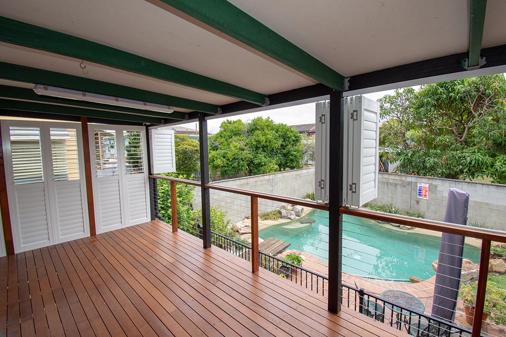 Pool overlooked by deck with folded plantation shutters | Featured image for the Shutters Brisbane Top Level Page on Shutters Blinds & Awnings