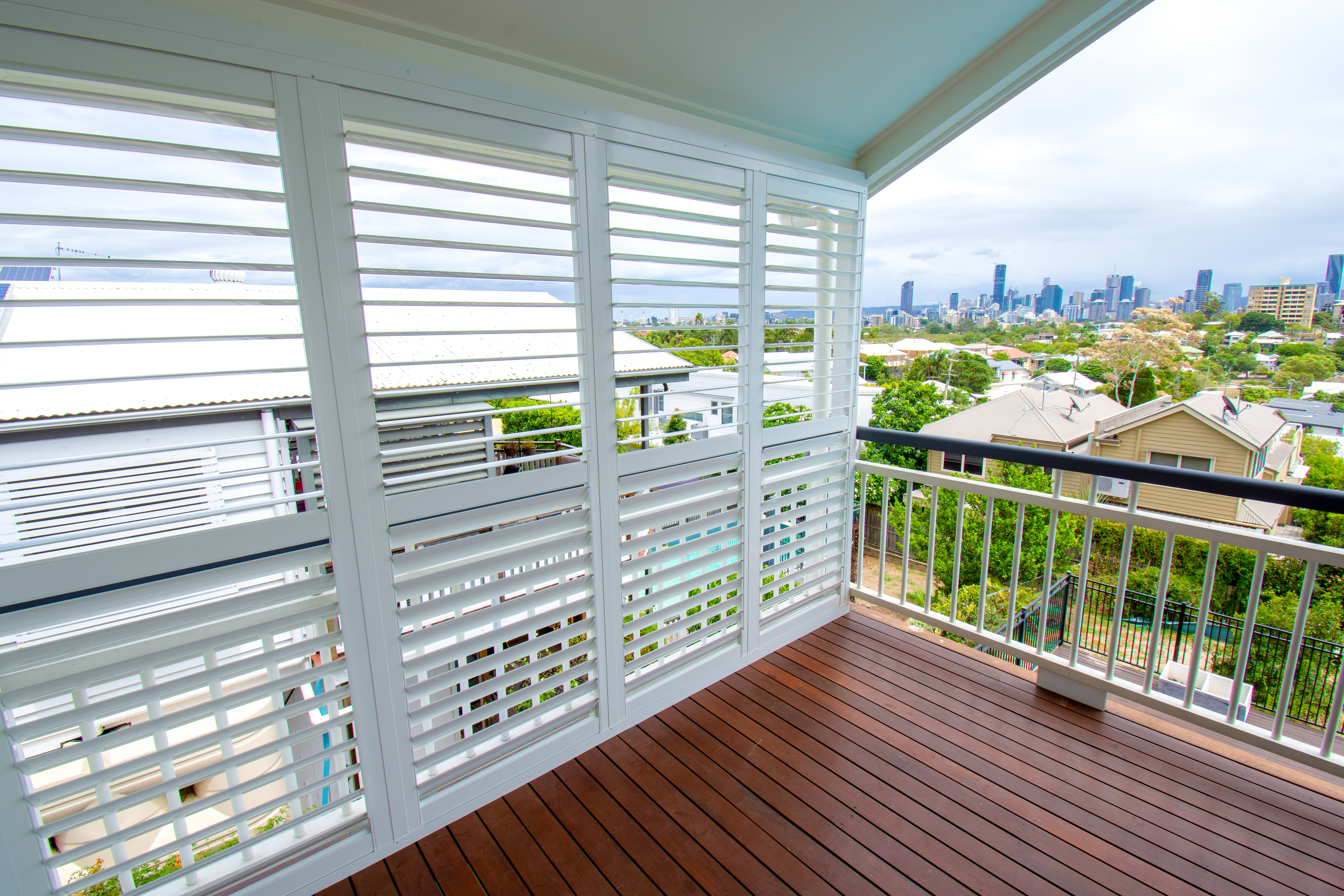 Outdoor area with Aluminium Shutters siding with the Brisbane Skyline in the background.